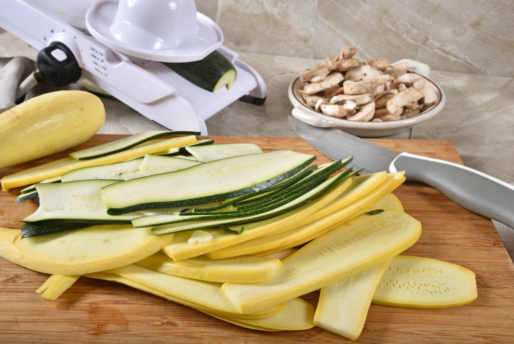 A cutting board with zucchini and various vegetables, ready to be prepared for a delicious meal.