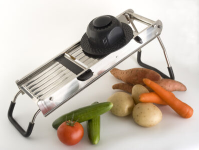 professional vegetable slicer and vegetables isolated on white