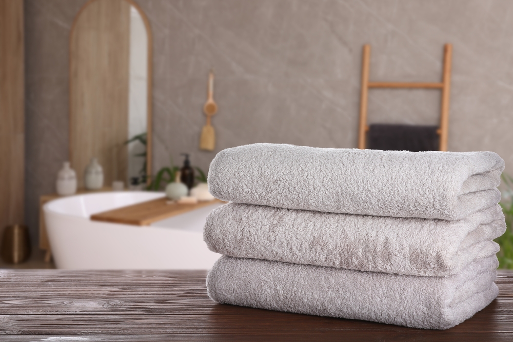 White clean towels on wooden table in bathroom. 