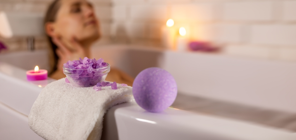 woman enjoying bathtub with sea salt crystals and bath bomb. home spa.