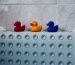 Plastic ducks in a row sitting on a bath mat